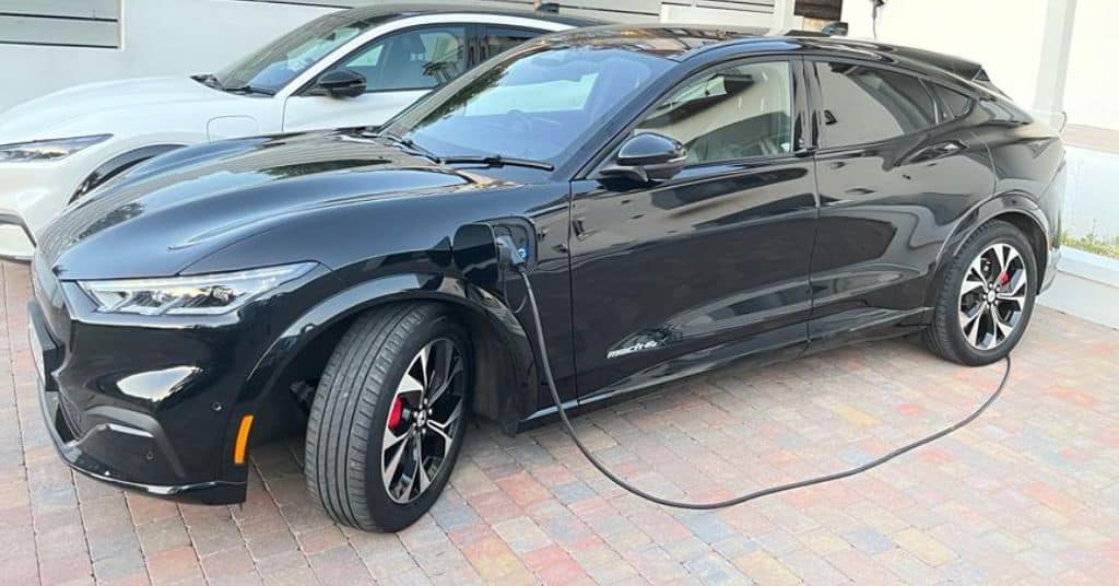 Pair of electric mustangs charging on a driveway